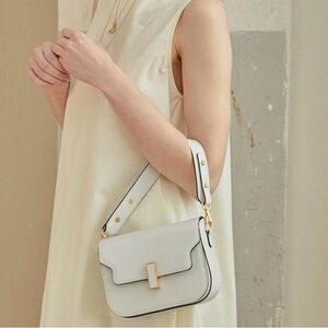 Three-way carry 100% leather bag with gold chain details.